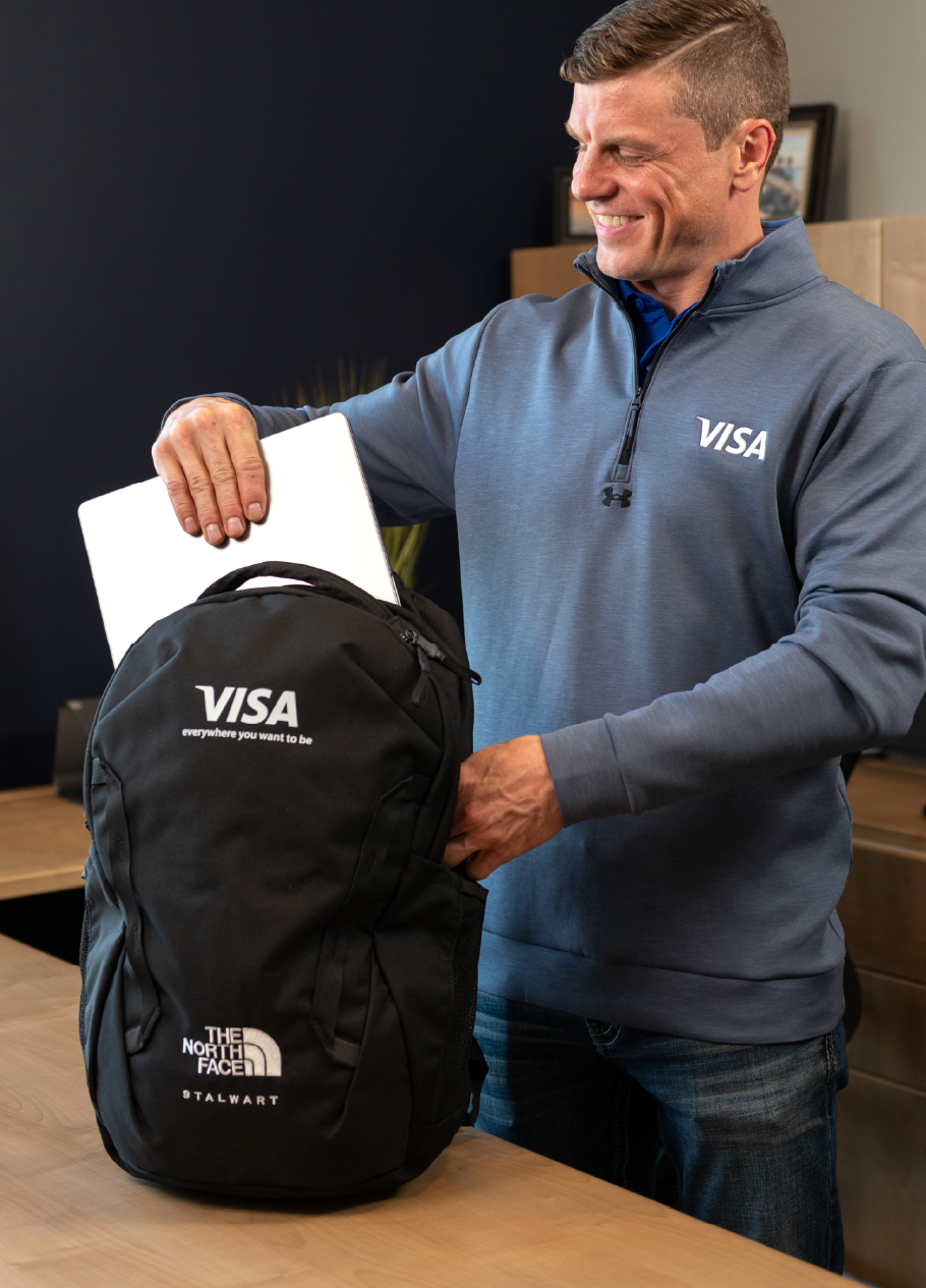 Person packing a branded backpack